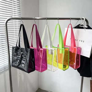 Five colorful transparent PVC jelly tote bags hanging neatly in a retail display setting