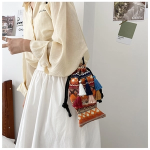 Ethno-Schultertasche in Fischform mit buntem Jacquard-Muster und lebhaften Quasten