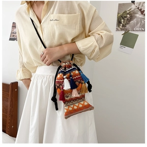 Ethno-Stricktasche in Fischform mit bunten Quasten und geometrischen Mustern am Schultergurt