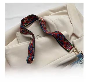Detail of ethnic geometric woven strap and light blue leather shoulder bag with gold hooks