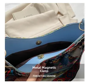 Detail view of ethnic embroidery bag featuring blue lining and magnetic metal clasp