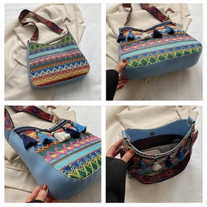 Detail view of ethnic crossbody bag with geometric weave patterns and blue tassels