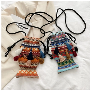 Detail der fischförmigen Boho-Webtasche mit ethnischen Mustern und farbigen Quasten