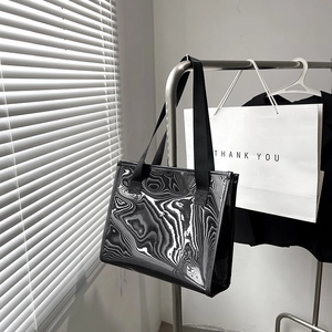 Women's tote bag featuring bold black and white liquid sand wave patterns on smooth fabric
