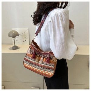 Close-up of bohemian shoulder bag featuring geometric patterns and colorful tassel charms