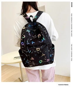 Close-up of black backpack with colorful gradient letter print and durable canvas texture