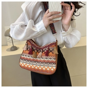 Detail of bohemian woven bag featuring colorful fringe tassels and ethnic embroidery strap