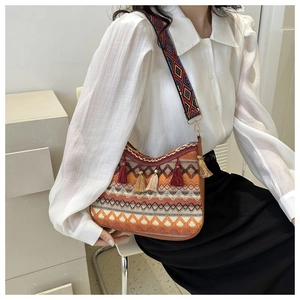 Detail of bohemian crossbody bag with ethnic print wide strap and colorful tassels