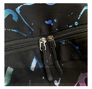 Close-up of smooth double zipper with cords on printed canvas backpack with ink splash pattern