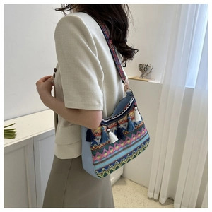 Close-up of ethnic crossbody bag featuring colorful embroidery and tricolor fringe tassels