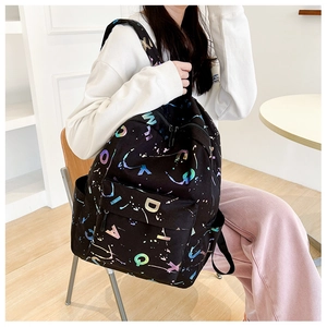 Detail of black backpack with colorful laser letter prints and wear-resistant canvas texture