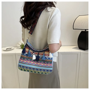 Detail of woven crossbody bag with colorful geometric patterns and long hanging tassels