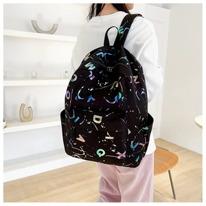 Detail of black canvas backpack with colorful gradient lettering and street style pattern