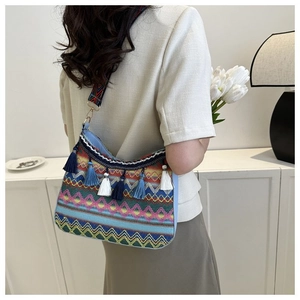 Detailed view of bohemian woven shoulder bag featuring colorful patterns and blue tassels