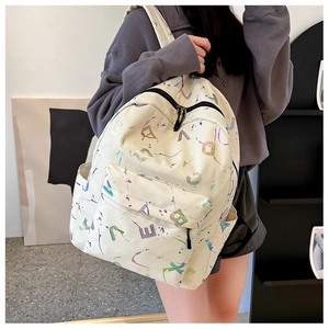 Close-up of beige canvas backpack featuring colorful ink splatters and laser print letters