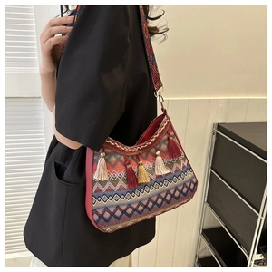 Detail of bohemian shoulder bag with colorful fringe tassels and ethnic woven strap