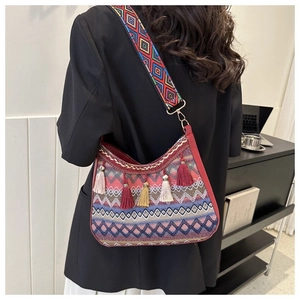 Close-up of bohemian shoulder bag with colorful tassels and ethnic geometric patterns