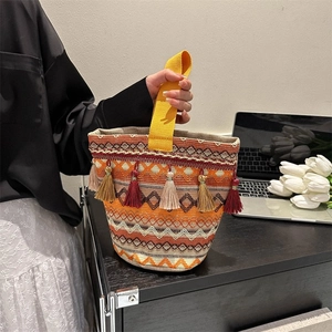 Dettaglio della borsa etnica intrecciata con nappe colorate e motivi geometrici