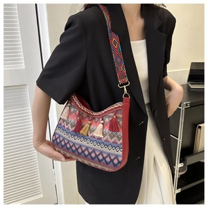Ethnic crossbody bag featuring geometric woven fabric, wide strap, and fringe tassels detail