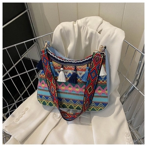 Detail of bohemian embroidery bag featuring vibrant geometric patterns and fringe tassels