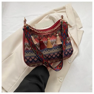 Close-up of bohemian crossbody bag with colorful tassels and geometric embroidered strap