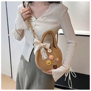 Sac bandoulière rond en paille d'été avec broderies florales et nœud en dentelle