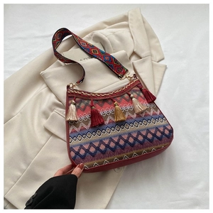Close-up of bohemian shoulder bag featuring ethnic embroidery and colorful tassel details