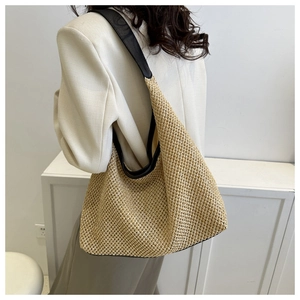 Detail shot of a large woven tote bag being worn to show size and casual style