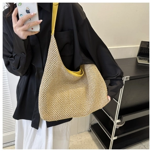 Detail of woven straw tote bag with yellow leather trim and matching shoulder strap