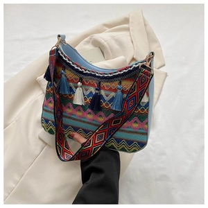 Close-up of bohemian woven shoulder bag with colorful fringe and embroidered wide strap