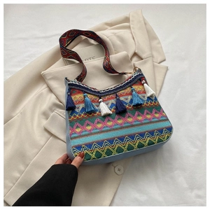 Detailed view of bohemian knitted shoulder bag with colorful fringe and woven strap