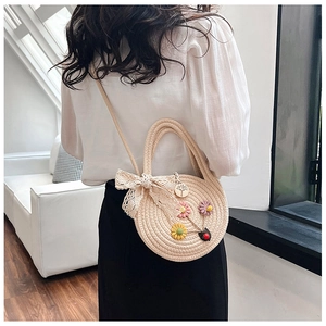 Détail du sac en paille tressée avec fleurs 3D et décoration délicate en dentelle