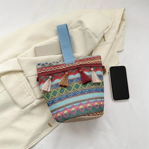 Dettaglio della borsa tessuta bohémien con motivi geometrici colorati e nappe decorative