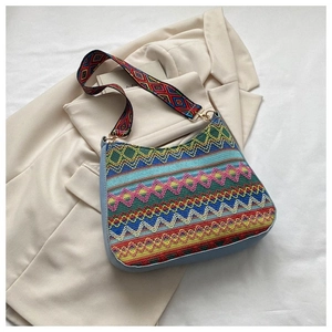 Detailed view of bohemian woven crossbody bag with colorful patterns and wide strap