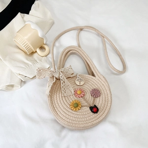 Dettaglio della mini borsa rotonda tessuta a mano con fiori 3D e fiocco in pizzo