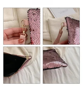Detailed close-up of pink sequin clutch showing metal hook, inner pocket and zip closure