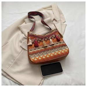 Close-up of Bohemian crossbody bag featuring geometric embroidery and colorful tassels