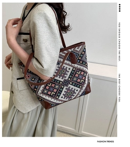 Detail of colorful geometric woven pattern and brown leather straps on a tote bag