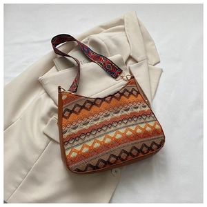 Detailed view of woven crossbody bag featuring colorful geometric patterns and wide strap