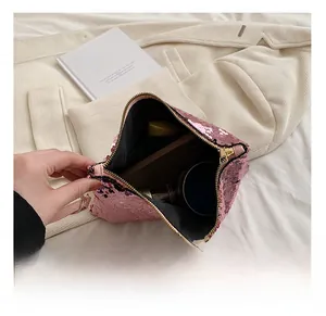 Pink sequin handbag with gold zipper showing internal storage for phone and cosmetics