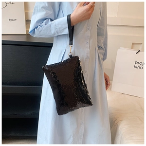 Detailed view of the black sequin evening bag with leather wrist strap and zip closure