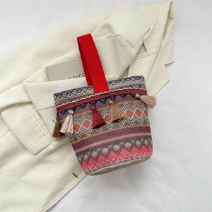 Dettaglio della borsa a secchiello etnica intrecciata con nappe e motivi geometrici