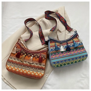 Detailed shot of two woven bohemian crossbody bags with colorful tassels and wide ethnic straps