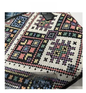 Close-up of geometric jacquard woven fabric with colorful folk patterns on a handbag