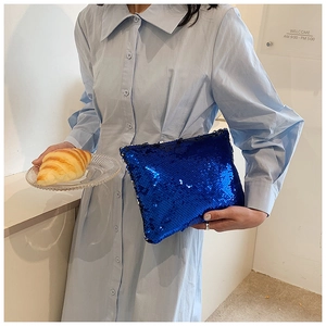 Sparkling dark blue sequin clutch bag held by model for evening party fashion