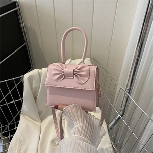 Detailed view of pink mini crossbody bag with a 3D bow design and textured PU finish