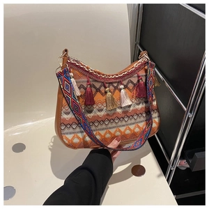 Detail of bohemian shoulder bag with ethnic weaving pattern and colorful tassels