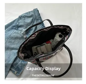 Interior capacity display of a woven tote bag holding phone, umbrella and cosmetics
