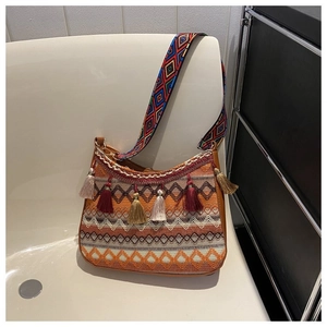 Detailed view of bohemian woven shoulder bag with colorful tassels and jacquard strap