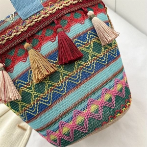 Dettaglio della borsa a secchiello boho con ricami geometrici colorati e nappe